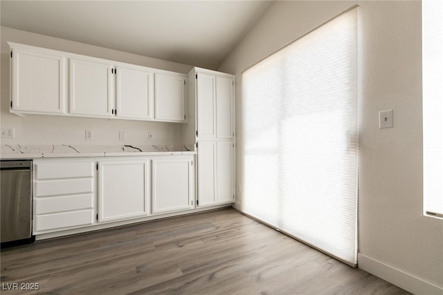 4825 White Aspen Ave, Las Vegas, NV 89130 - kitchen with dishwasher, white cabinetry, light countertops, and vaulted ceiling