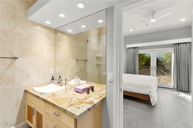 5680 N Fort Apache Rd, Las Vegas, NV 89149 - bathroom featuring french doors, vanity, tile patterned floors, tile walls, and a ceiling fan