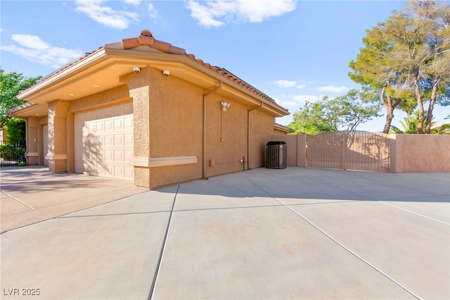 5680 N Fort Apache Rd, Las Vegas, NV 89149 - view of side of property featuring concrete driveway, an attached garage, a gate, stucco siding, and a tiled roof
