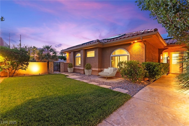 5680 N Fort Apache Rd, Las Vegas, NV 89149 - view of front facade with a gate, solar panels, a tile roof, and stucco siding