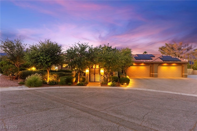 5680 N Fort Apache Rd, Las Vegas, NV 89149 - view of front of property featuring solar panels, driveway, an attached garage, a tile roof, and stucco siding