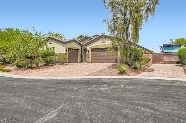 8732 Kendall Brook Cir, Las Vegas, NV 89149 - mediterranean / spanish home with stucco siding, a gate, an attached garage, decorative driveway, and a tiled roof