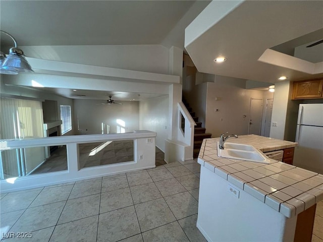8704 Autumn Wreath Ave, Las Vegas, NV 89129 - kitchen with tile countertops, dishwasher, a ceiling fan, vaulted ceiling, and a center island with sink
