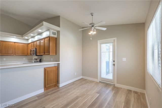 370 Manti Pl Unit 21, Henderson, NV 89014 - kitchen featuring appliances with stainless steel finishes, brown cabinets, light countertops, light wood-style flooring, and lofted ceiling