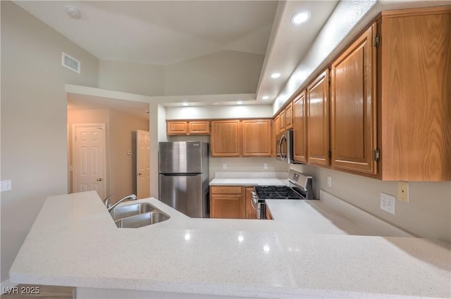 370 Manti Pl Unit 21, Henderson, NV 89014 - kitchen featuring appliances with stainless steel finishes, brown cabinets, a peninsula, recessed lighting, and light stone counters