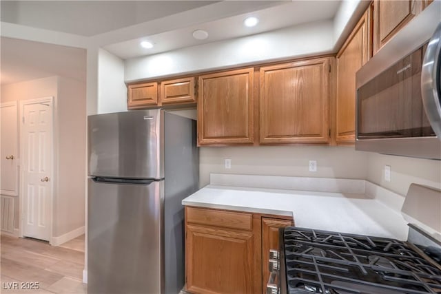 370 Manti Pl Unit 21, Henderson, NV 89014 - kitchen with stainless steel appliances, light countertops, recessed lighting, light wood-type flooring, and brown cabinetry