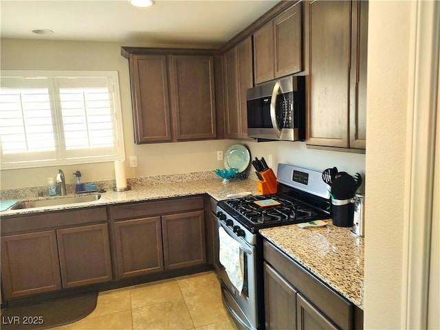 2822 Chetco River St, Laughlin, NV 89029 - kitchen with stainless steel appliances, light tile patterned floors, light stone counters, recessed lighting, and dark brown cabinetry