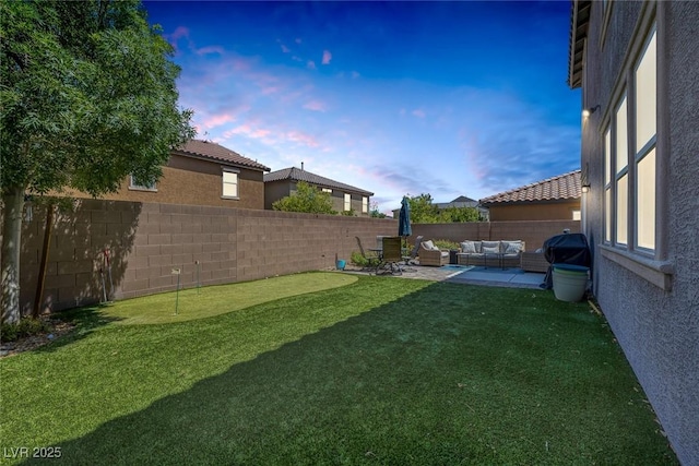 7890 S Miller Ln, Las Vegas, NV 89113 - yard at dusk with an outdoor hangout area, a putting green, a fenced backyard, and a patio