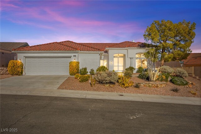 10920 Grand Haven Ave, Las Vegas, NV 89134 - mediterranean / spanish house featuring a tile roof, an attached garage, stucco siding, and driveway