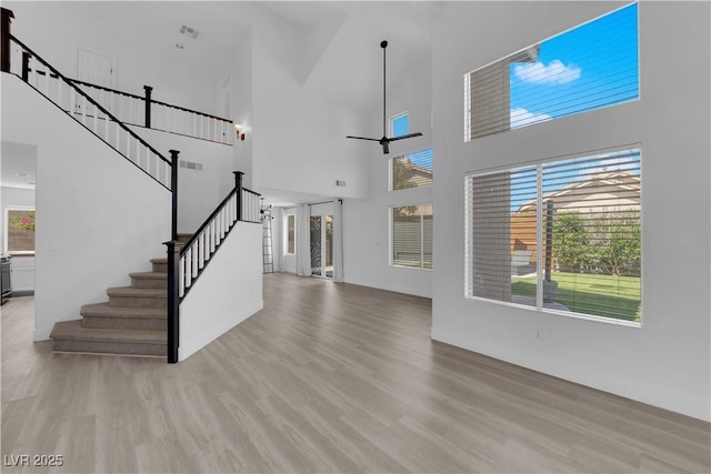 21 Rue De Degas, Henderson, NV 89074 - unfurnished living room featuring a high ceiling, light wood-style floors, stairway, and ceiling fan