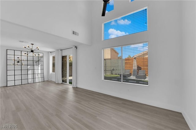21 Rue De Degas, Henderson, NV 89074 - unfurnished living room with wood finished floors, plenty of natural light, and a chandelier