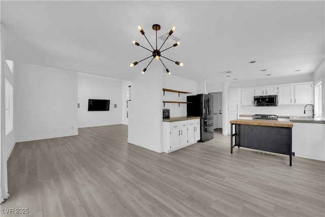 21 Rue De Degas, Henderson, NV 89074 - unfurnished living room featuring a chandelier and light wood finished floors