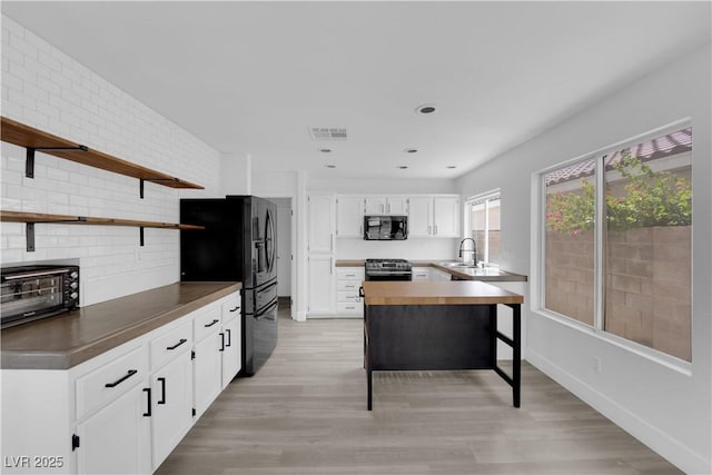 21 Rue De Degas, Henderson, NV 89074 - kitchen with black appliances, open shelves, light wood-style floors, white cabinetry, and recessed lighting