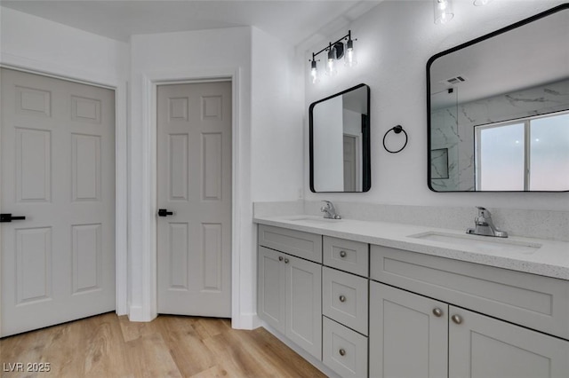 6126 Bedrock Ct, North Las Vegas, NV 89031 - bathroom with double vanity, wood finished floors, and a marble finish shower