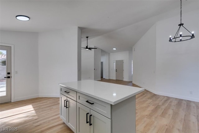 6126 Bedrock Ct, North Las Vegas, NV 89031 - kitchen with light wood-type flooring, light countertops, hanging light fixtures, a chandelier, and a kitchen island