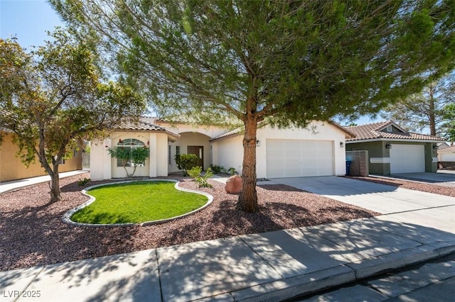 6126 Bedrock Ct, North Las Vegas, NV 89031 - mediterranean / spanish home with stucco siding, concrete driveway, an attached garage, and a tiled roof