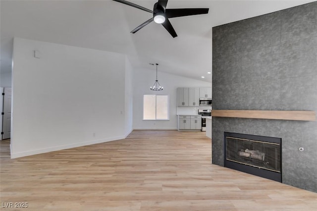 6126 Bedrock Ct, North Las Vegas, NV 89031 - unfurnished living room with lofted ceiling, a ceiling fan, light wood-type flooring, a fireplace, and a chandelier