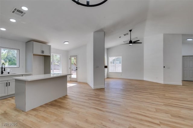 6126 Bedrock Ct, North Las Vegas, NV 89031 - kitchen featuring lofted ceiling, light countertops, light wood-style floors, a center island, and open floor plan