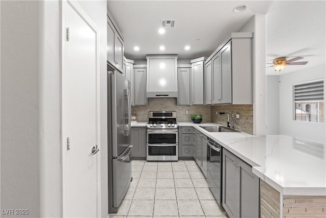 6635 Caporetto Ln Unit 204, North Las Vegas, NV 89084 - kitchen with appliances with stainless steel finishes, gray cabinetry, decorative backsplash, ceiling fan, and light tile patterned floors