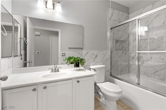 6635 Caporetto Ln Unit 204, North Las Vegas, NV 89084 - full bathroom with bath / shower combo with glass door, vanity, tile walls, and wainscoting