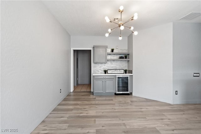 6635 Caporetto Ln Unit 204, North Las Vegas, NV 89084 - kitchen featuring gray cabinets, beverage cooler, open shelves, a chandelier, and backsplash