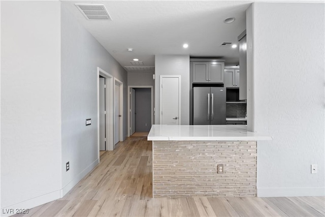 6635 Caporetto Ln Unit 204, North Las Vegas, NV 89084 - kitchen with freestanding refrigerator, gray cabinetry, light wood-style flooring, a peninsula, and recessed lighting