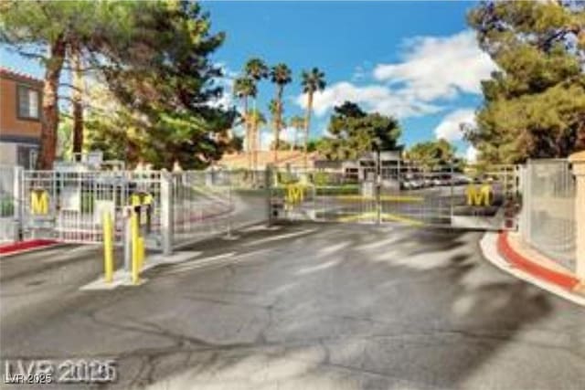 221 Mission Catalina Ln Unit 104, Las Vegas, NV 89107 - view of asphalt street featuring a gated entry, curbs, and a gate