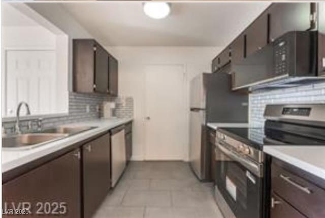 221 Mission Catalina Ln Unit 104, Las Vegas, NV 89107 - kitchen with appliances with stainless steel finishes, backsplash, light tile patterned floors, and light countertops