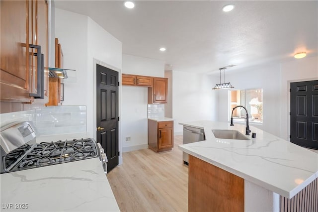 8798 Tom Noon Ave Unit 103, Las Vegas, NV 89178 - kitchen featuring brown cabinetry, stainless steel appliances, decorative backsplash, a center island with sink, and recessed lighting