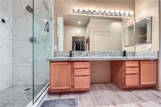 2325 Windmill Pkwy Unit 1622, Henderson, NV 89074 - full bath featuring a stall shower, double vanity, wood finished floors, and a walk in closet