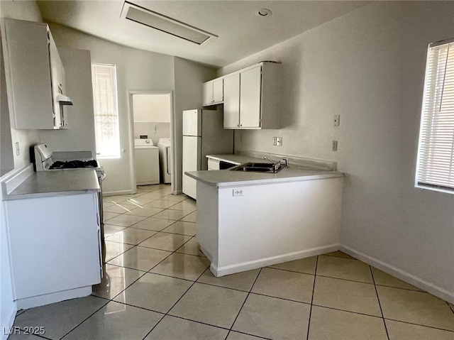2405 Prime Advantage Ave, North Las Vegas, NV 89032 - kitchen with independent washer and dryer, light tile patterned flooring, freestanding refrigerator, and light countertops