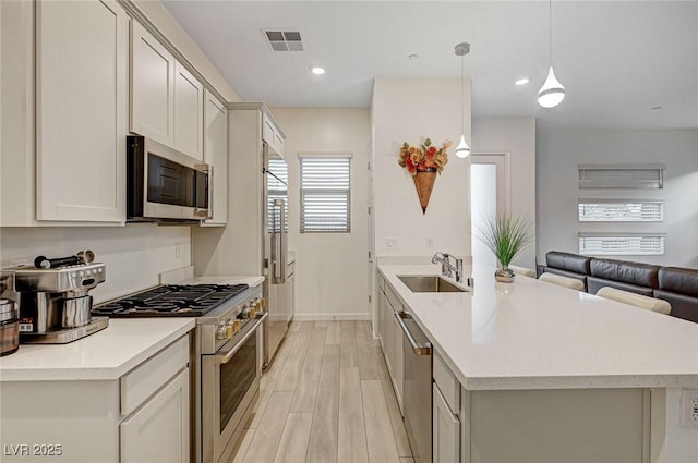 912 Allister Fields Ln, Las Vegas, NV 89138 - kitchen featuring stainless steel appliances, a peninsula, open floor plan, light wood-type flooring, and light countertops