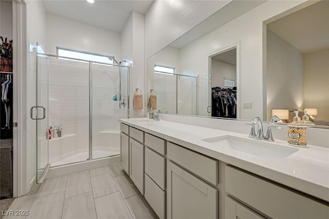 912 Allister Fields Ln, Las Vegas, NV 89138 - bathroom with a walk in closet, double vanity, a stall shower, tile patterned floors, and recessed lighting