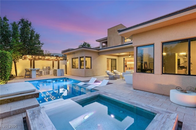 38 Moonfire Dr, Las Vegas, NV 89135 - pool at dusk with an in-ground hot tub, a patio area, and area for grilling