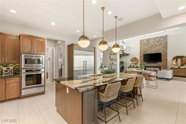 38 Moonfire Dr, Las Vegas, NV 89135 - kitchen with built in appliances, recessed lighting, a warming drawer, a kitchen bar, and dark stone countertops