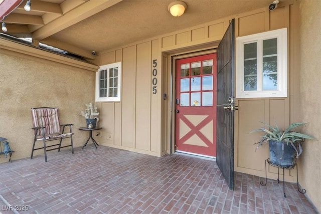 5005 Harmony Ave, Las Vegas, NV 89107 - view of exterior entry with a surveillance system, board and batten siding, and stucco siding