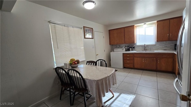 5209 Del Monte Ave, Las Vegas, NV 89146 - kitchen featuring washer / clothes dryer, light countertops, tasteful backsplash, and brown cabinetry