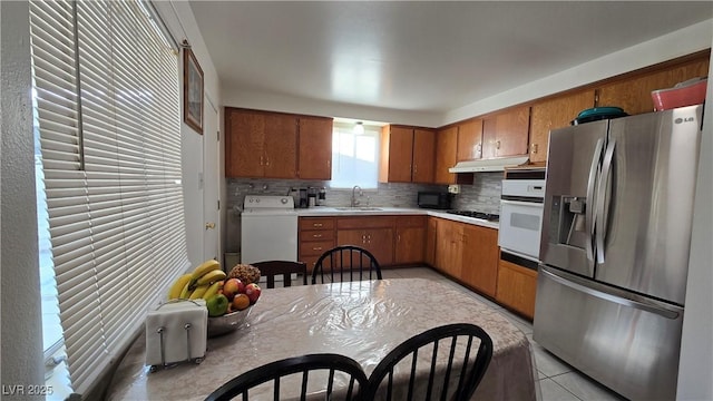 5209 Del Monte Ave, Las Vegas, NV 89146 - kitchen with stainless steel fridge, white oven, tasteful backsplash, and brown cabinets