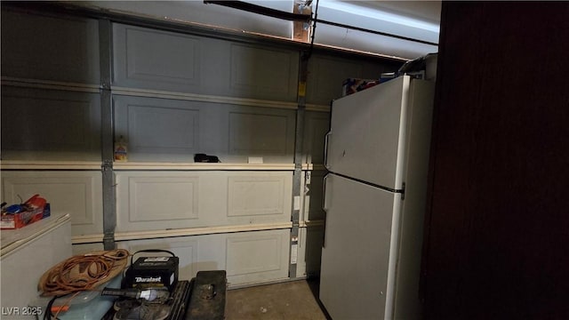 5209 Del Monte Ave, Las Vegas, NV 89146 - garage with freestanding refrigerator and a decorative wall
