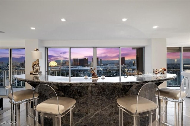 3111 Bel Air Dr Unit 21A & 21C, Las Vegas, NV 89109 - kitchen featuring recessed lighting, a breakfast bar, tile patterned floors, stone counters, and a view of city
