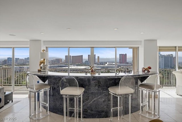 3111 Bel Air Dr Unit 21A & 21C, Las Vegas, NV 89109 - kitchen featuring a skyline view, light tile patterned flooring, and a kitchen breakfast bar