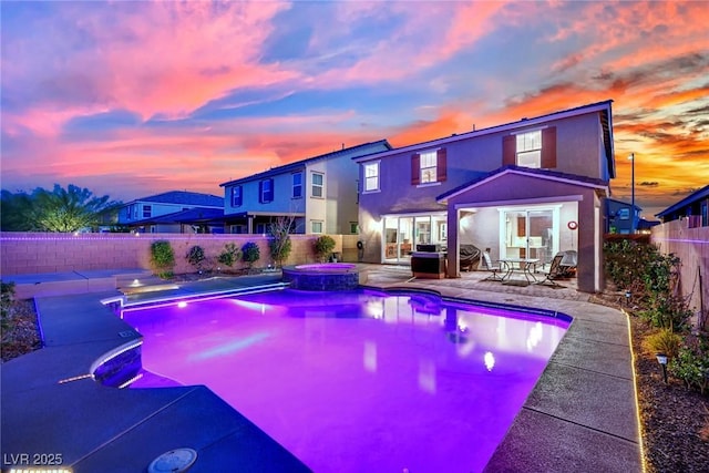 2714 Frabiele St, Henderson, NV 89044 - back of house at dusk featuring a fenced backyard, a patio, stucco siding, and a pool with connected hot tub