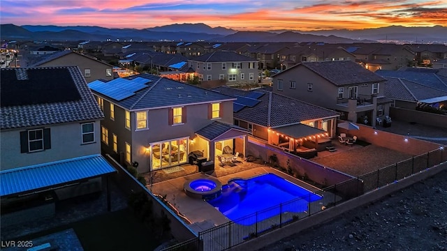 2714 Frabiele St, Henderson, NV 89044 - pool at dusk featuring a residential view, a fenced backyard, a pool with connected hot tub, and a mountain view