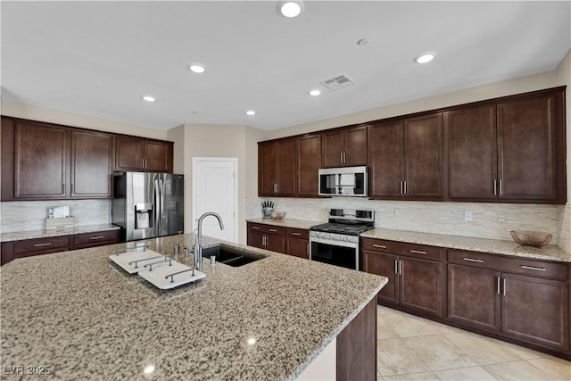 2714 Frabiele St, Henderson, NV 89044 - kitchen with appliances with stainless steel finishes, tasteful backsplash, light stone counters, dark brown cabinets, and recessed lighting