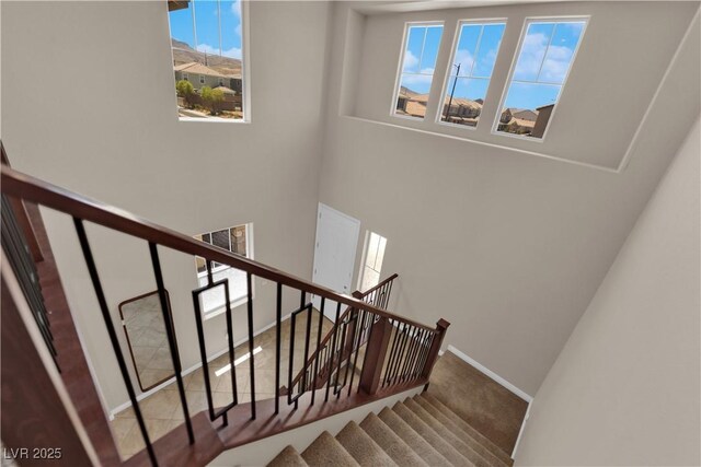 2714 Frabiele St, Henderson, NV 89044 - staircase featuring healthy amount of natural light, a towering ceiling, and carpet flooring