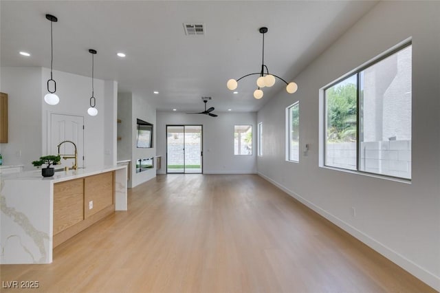 10452 Niagara Falls Ln, Las Vegas, NV 89144 - kitchen featuring light wood-style floors, ceiling fan, light countertops, pendant lighting, and recessed lighting