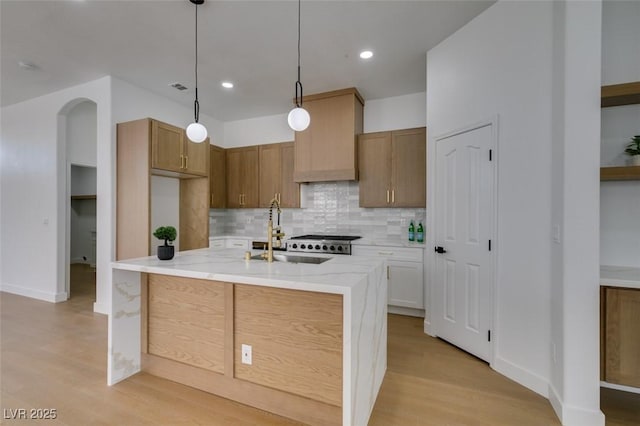 10452 Niagara Falls Ln, Las Vegas, NV 89144 - kitchen featuring tasteful backsplash, light wood-style floors, light stone counters, pendant lighting, and recessed lighting