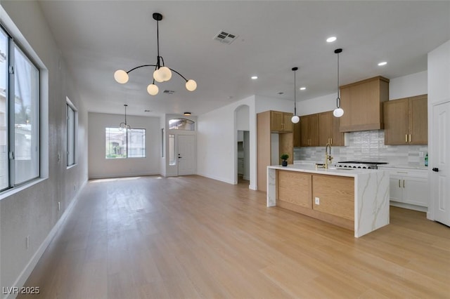 10452 Niagara Falls Ln, Las Vegas, NV 89144 - kitchen featuring a chandelier, light countertops, tasteful backsplash, light wood finished floors, and recessed lighting
