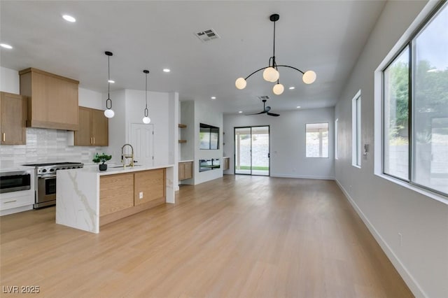 10452 Niagara Falls Ln, Las Vegas, NV 89144 - kitchen with appliances with stainless steel finishes, recessed lighting, light wood-type flooring, tasteful backsplash, and pendant lighting