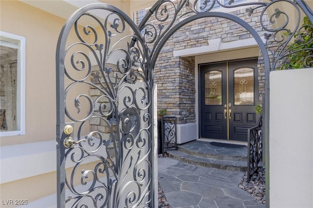 712 Proud Eagle Ln, Las Vegas, NV 89144 - view of exterior entry featuring a gate, french doors, and stone siding
